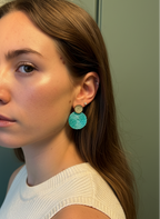 Woman wearing turquoise earrings against a neutral background