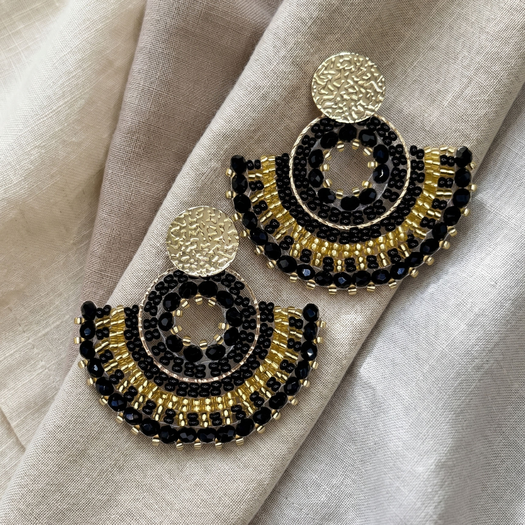 Black beaded earrings on linen cloth
