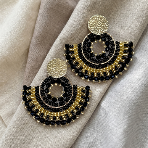 Black beaded earrings on linen cloth
