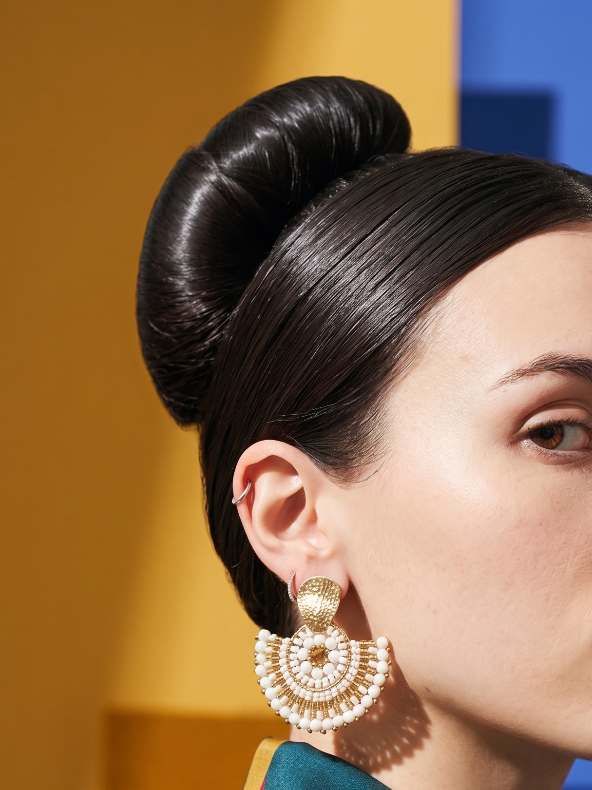 White beaded earring worn by woman with black hair