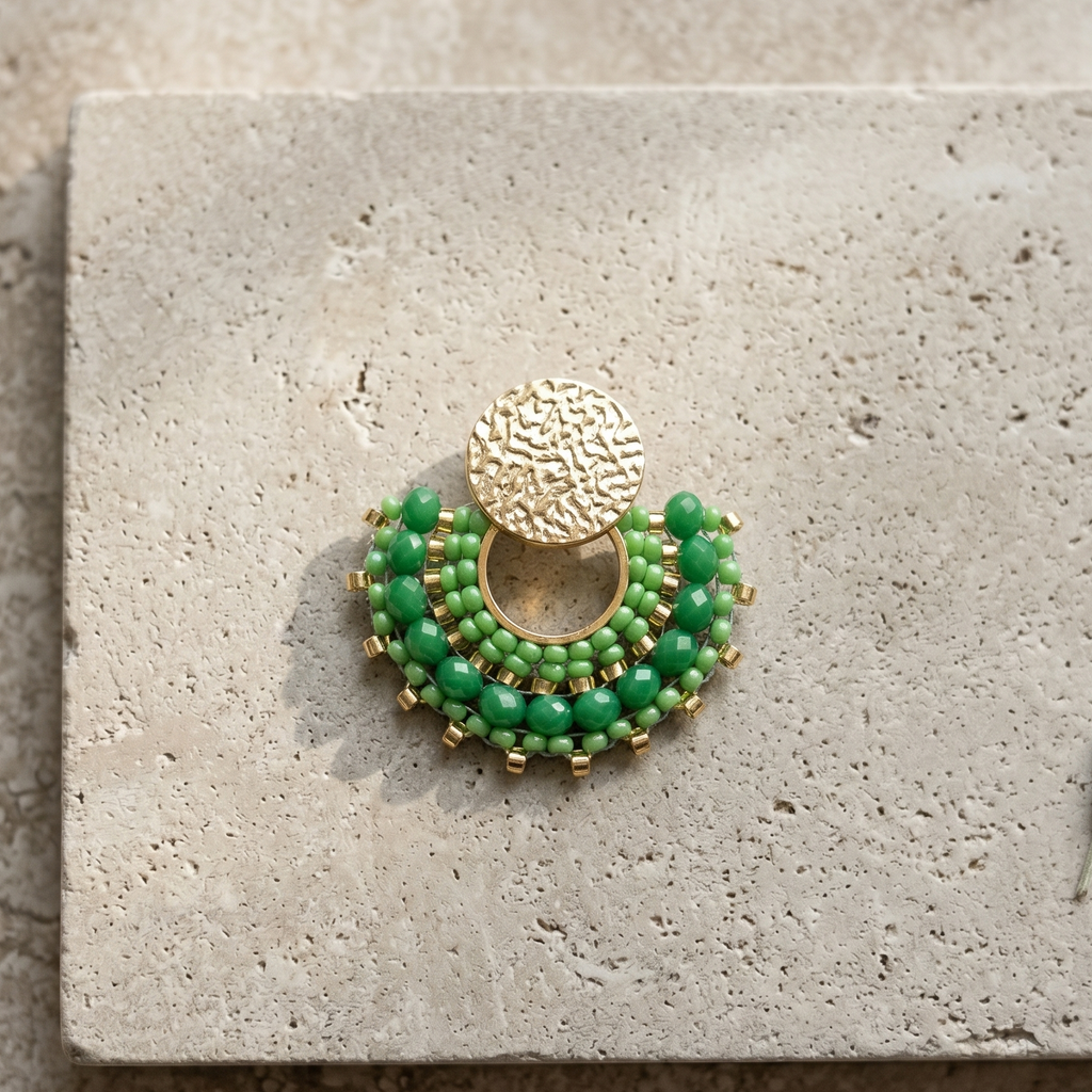 Green ebaded earrings on stone surface