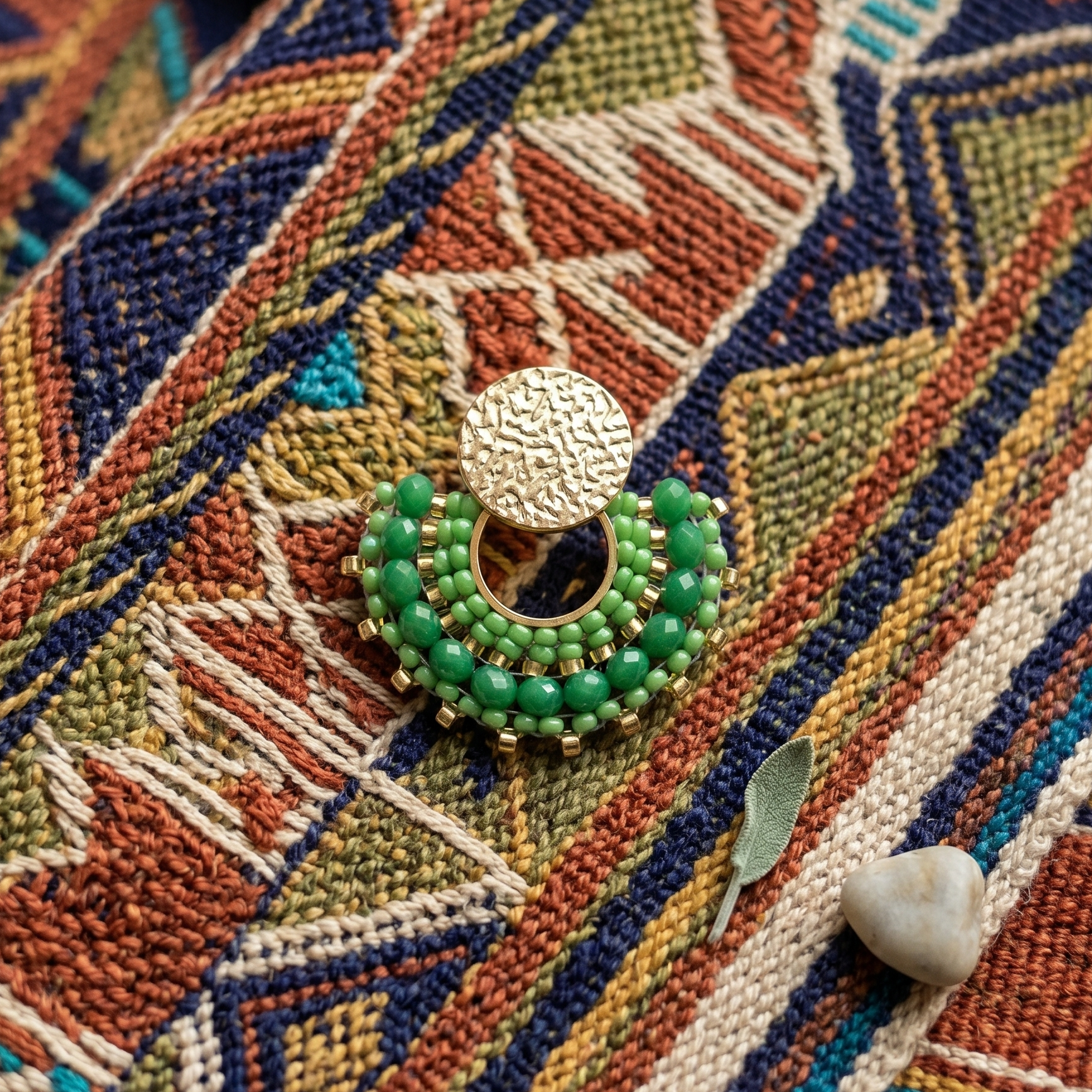 Green beaded earring on textile surface