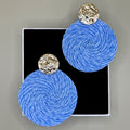 Blue spherical earrings with gold circular tops on a gray background