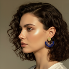 Woman wearing blue and gold earrings with a neutral background