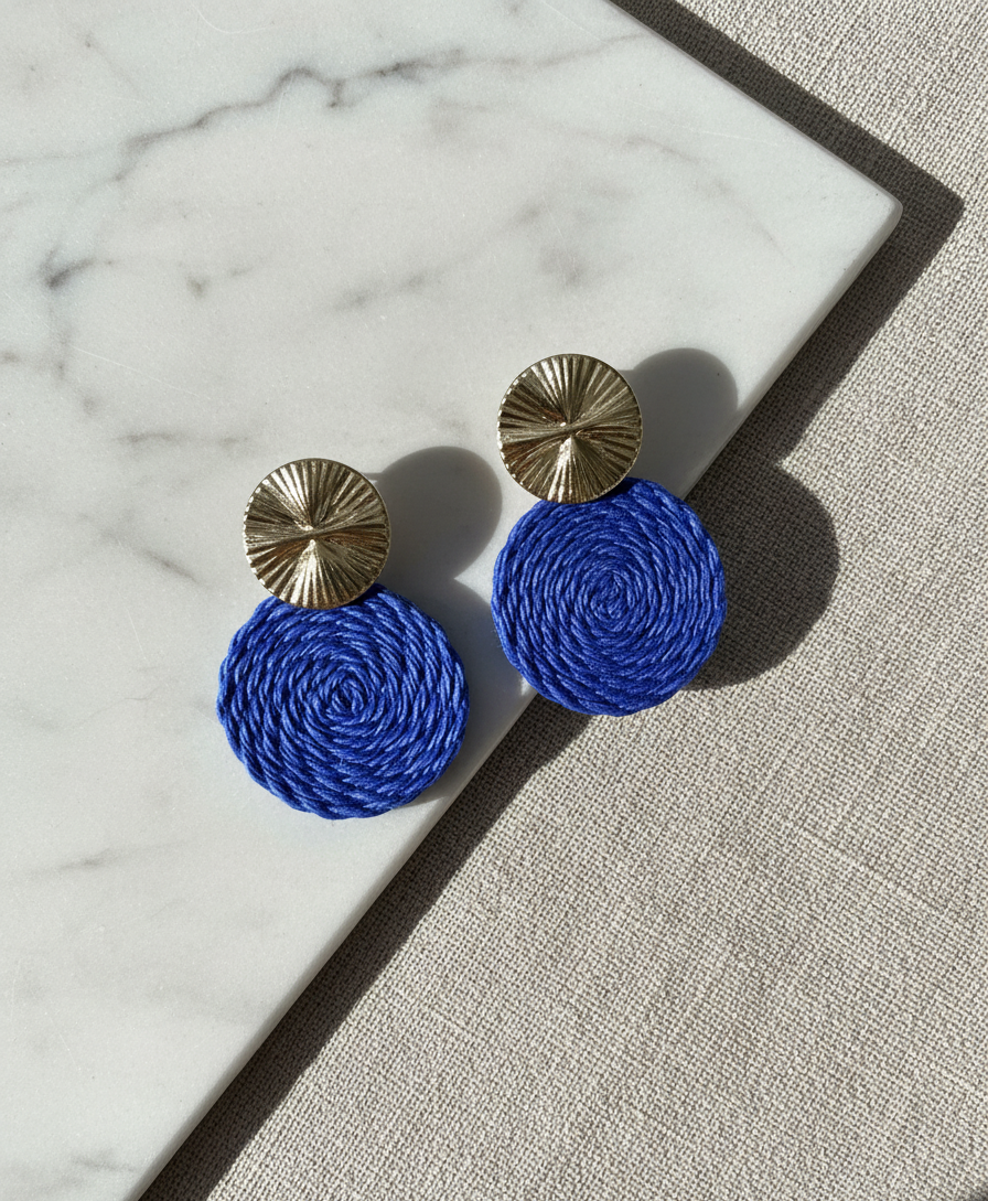 Blue Guatapé earrings with gold tops on a marble surface