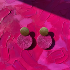 Pair of pink and gold earrings on a textured pink background