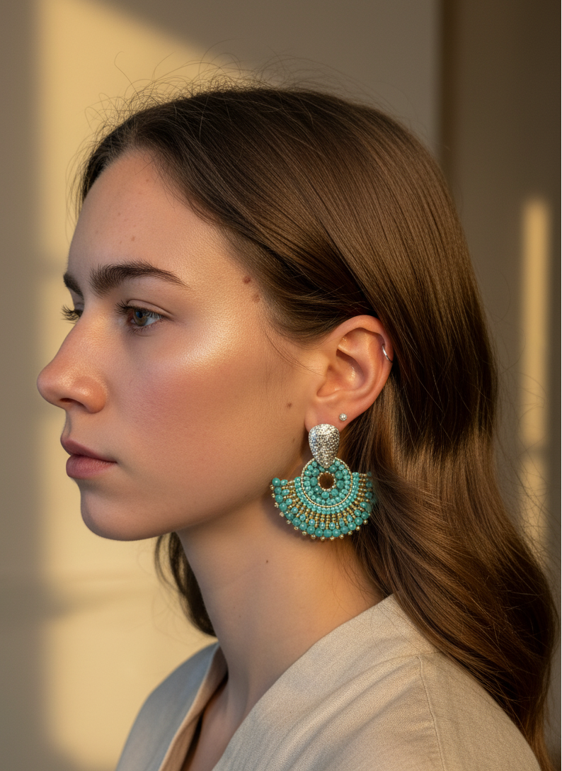 Woman wearing light blue earrings with a blurred background