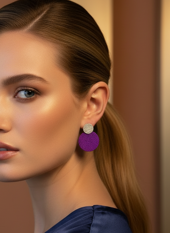 Woman wearing magenta earrings with a blurred background