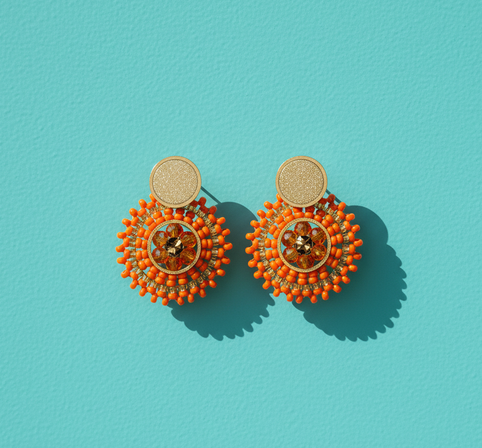 Orange beaded round earrings on a light blue surface
