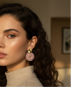Woman wearing pink earrings with a neutral background