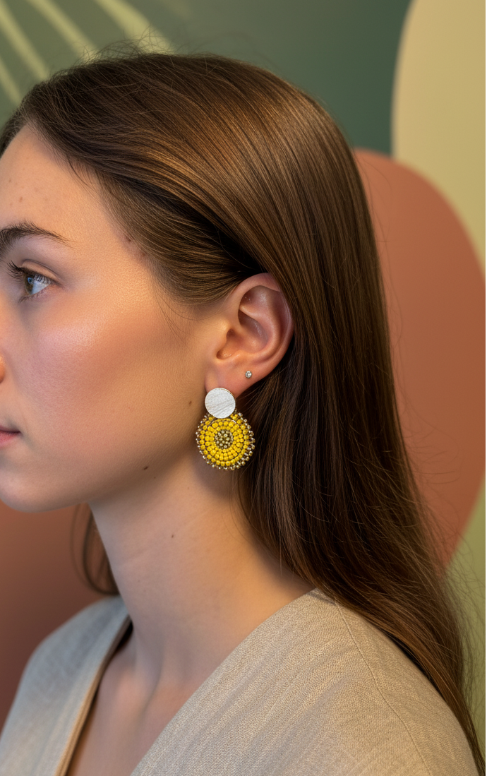 Woman wearing yellow earrings with a neutral background