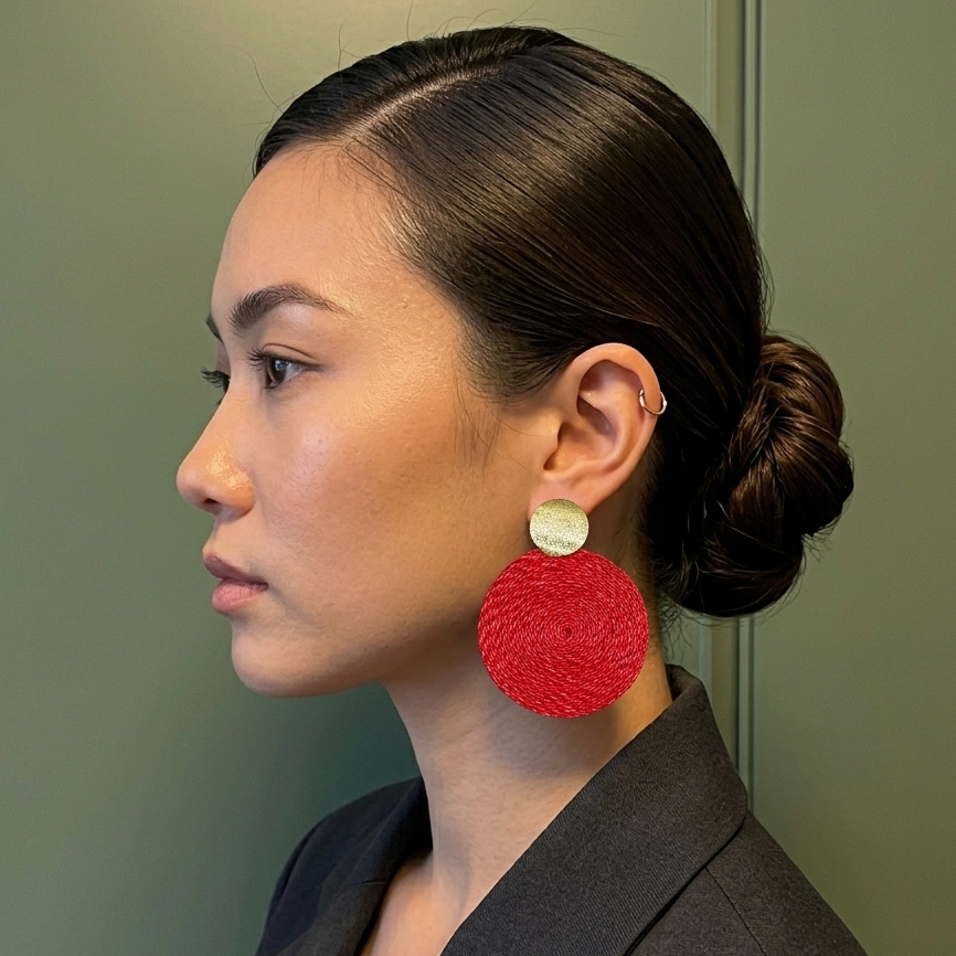 Woman wearing red earrings against a green background