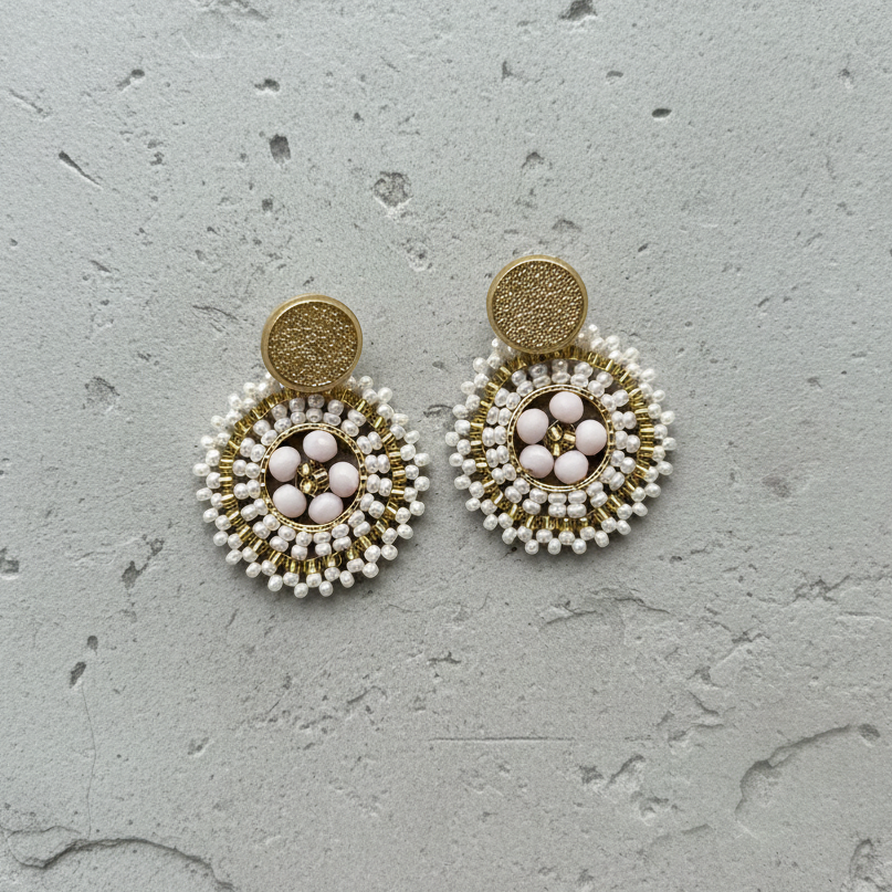 Pair of beaded earrings on a textured gray surface